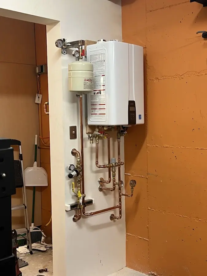 Plumbing technician inspecting water heater connections in Argo
